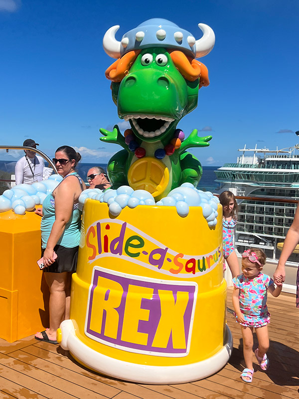Rex from Toy Story dressed as a viking atop a yellow tub of bubbles that reads "Slide-a-saurus Rex"