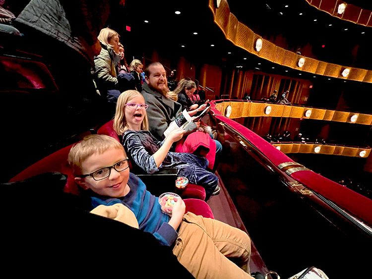 a family in seats at the David H. Koch Theatre in Lincoln Center waiting to watch The Nutcracker