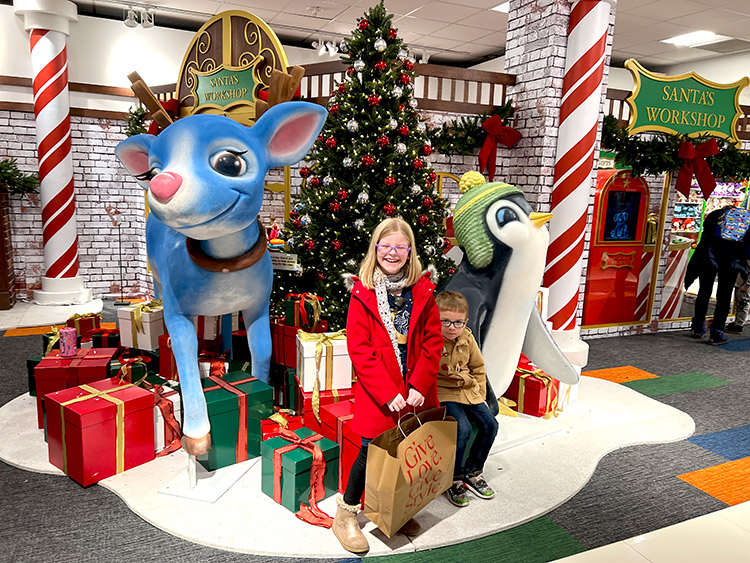 a boy and girl posing in front of Santa's Workshop on the seventh floor of Macy's in Herald Square