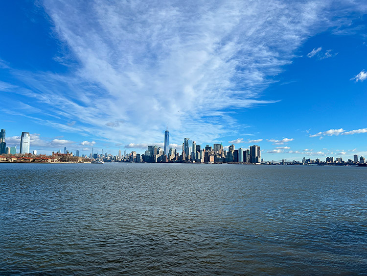 a wide daytime view of the New York City skyline from the Hudson River
