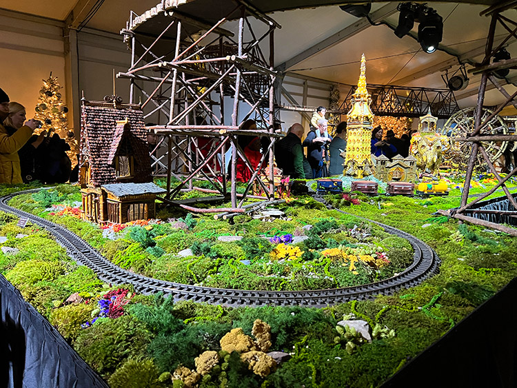 a view of greenery, train tracks, and miniature landmarks from the NYBG Holiday Train Show