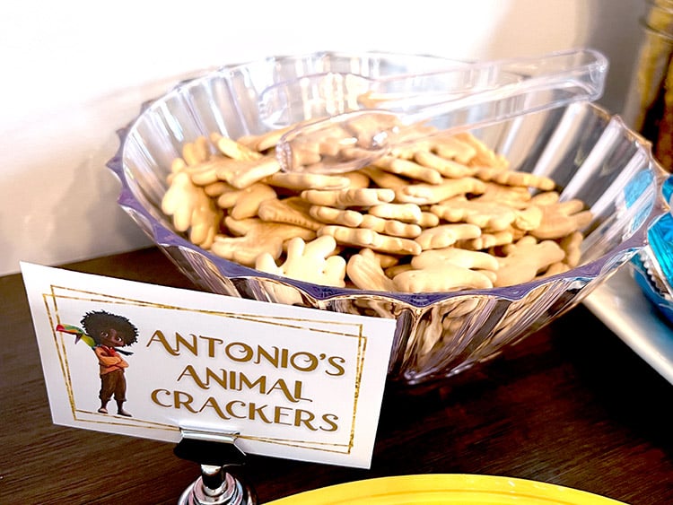 a bowl full of animal crackers and a card featuring Antonio from Encanto and the text "Antonio's animal crackers"