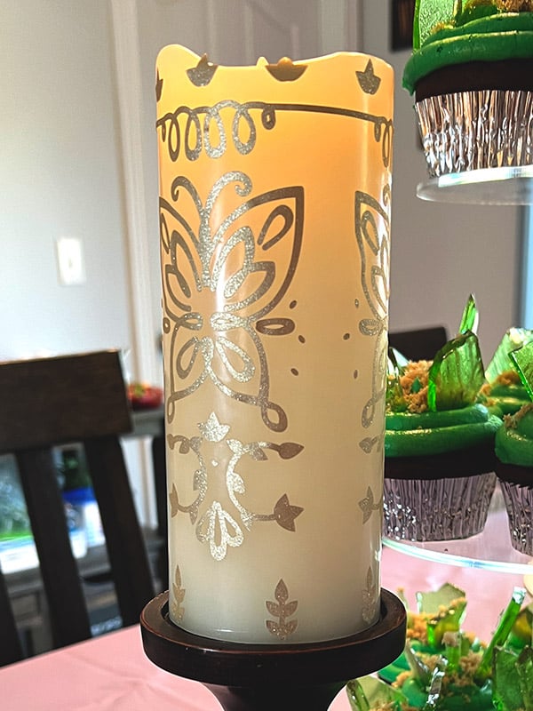 a glowing LED candle decorated with the Encanto candle design