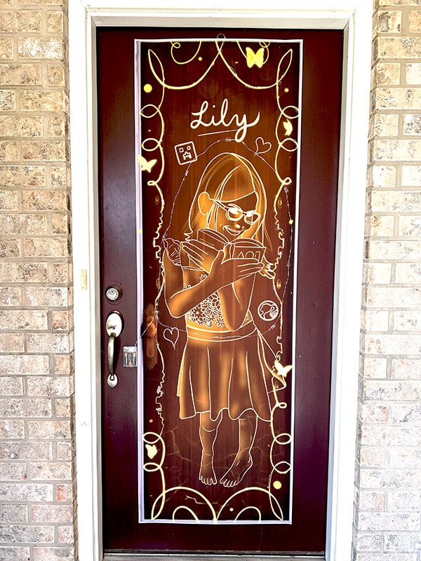 front door with a large banner covering it made to look like a real-life glowing Encanto door