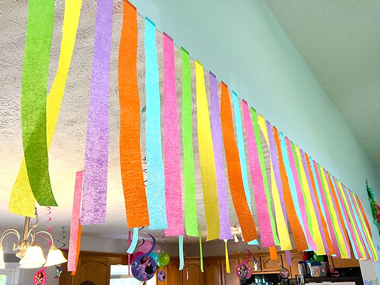 colorful streamers hanging from the ceiling in Encanto themed colors