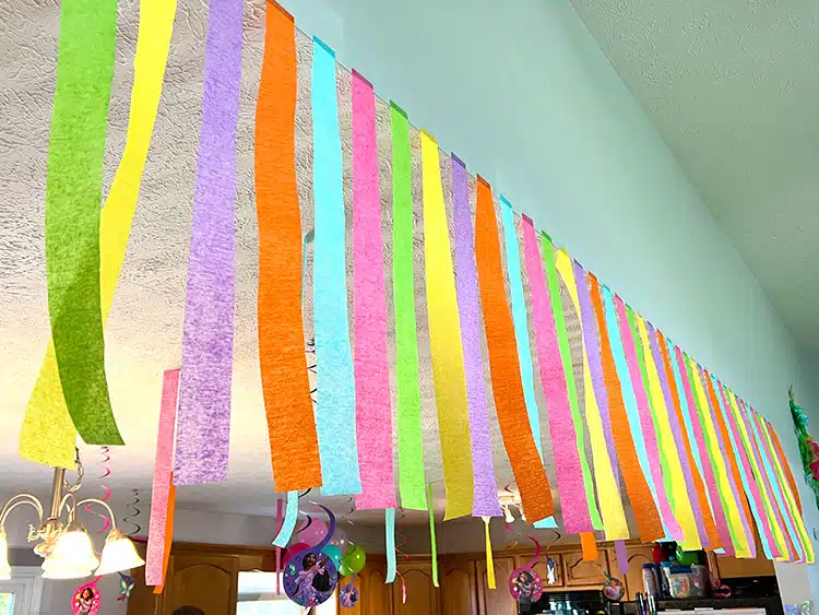 colorful streamers hanging from the ceiling in Encanto themed colors