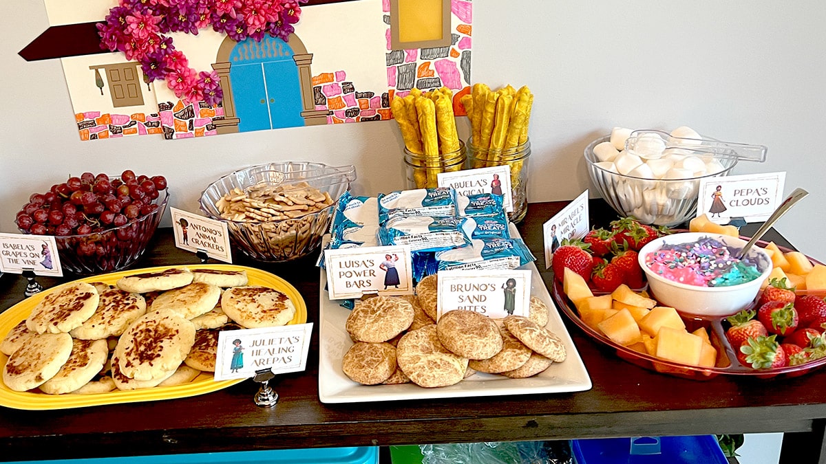 a kitchen server covered in Encanto birthday party foods