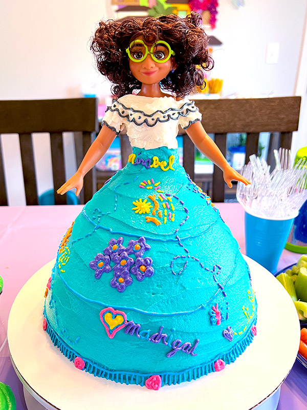a barbie doll birthday cake made to look like Mirabel Madrigal from Encanto