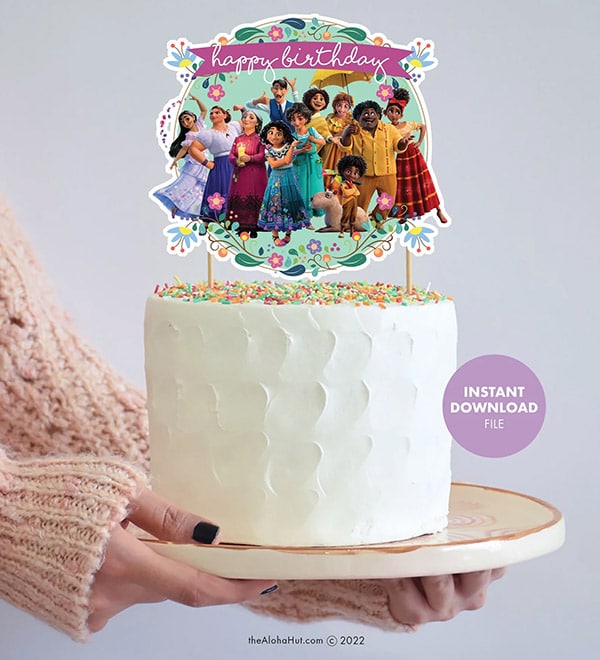 female hands holding a cake featuring a printable Encanto cake topper