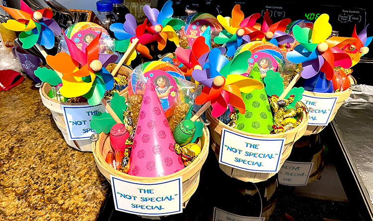 small baskets filled with brightly colored party favors and candy with a sign on each one reading "The 'Not Special' Special"