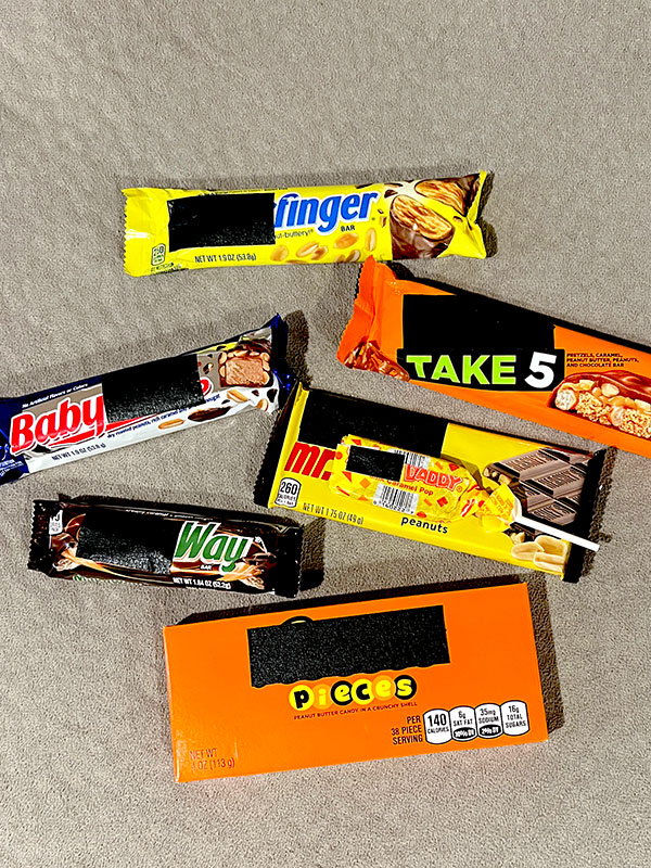 various candies with black tape over the parts of their names that don't fit into regular conversation (such as tape over the "Reese's" in Reese's Pieces)
