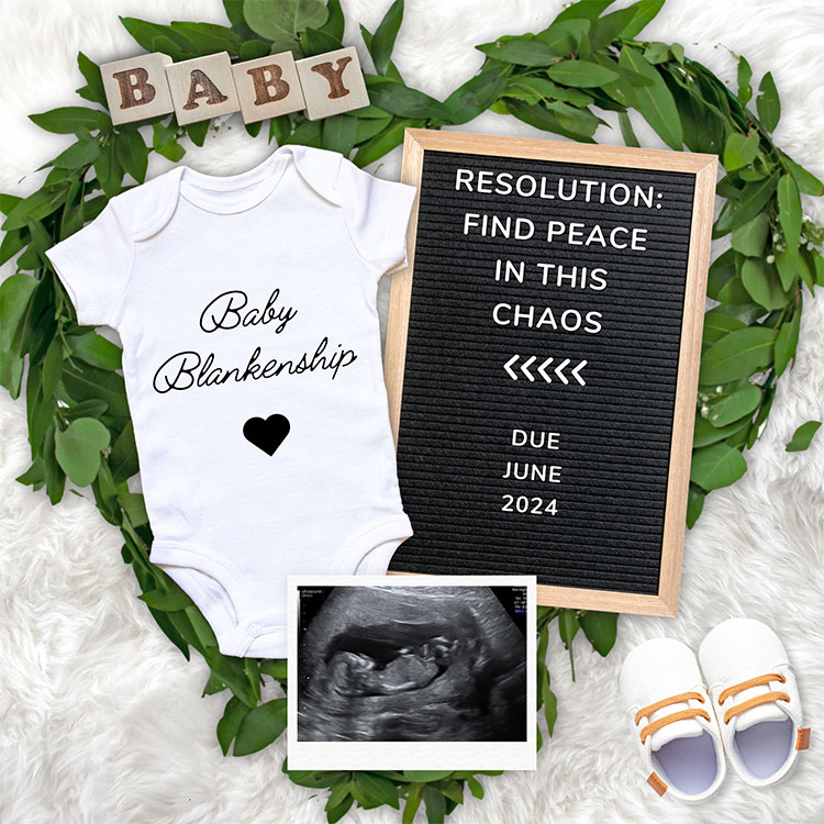 flat lay with a onesie, letter board and sonogram photo