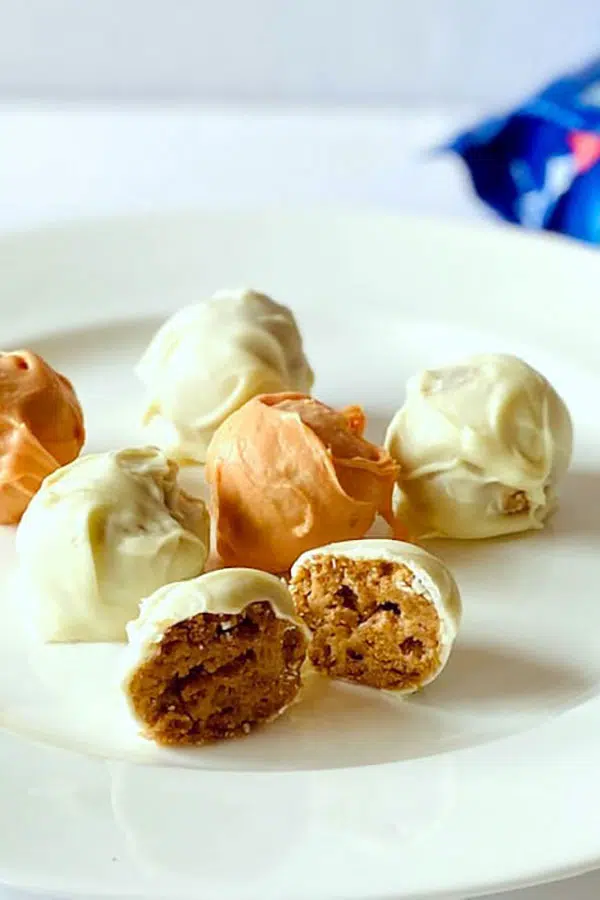 a white plate of carrot cake Oreo truffles with some cut in half to reveal the inside