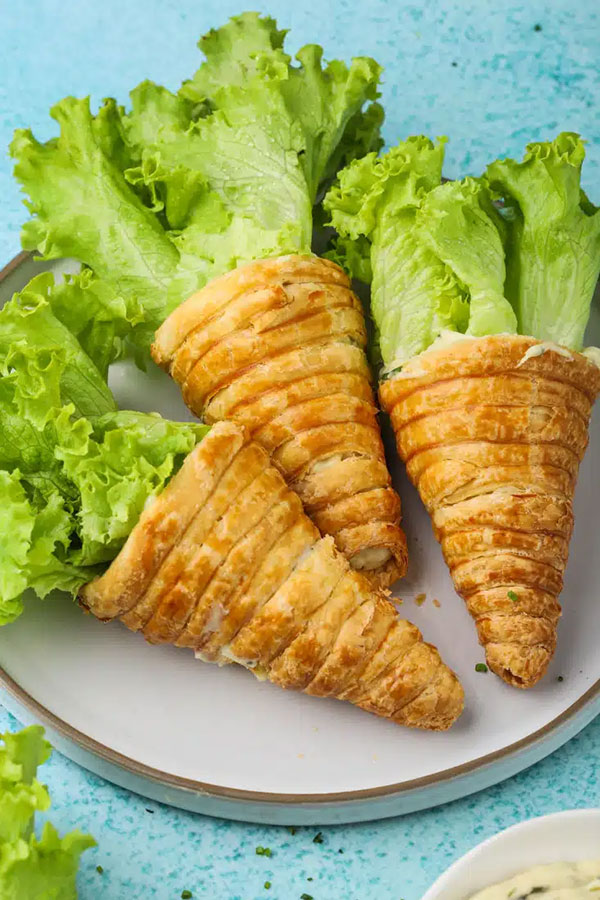 pastries made to look like large carrots with lettuce pieces sticking out of the top