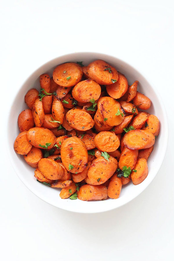 a white bowl full of roasted carrot slices