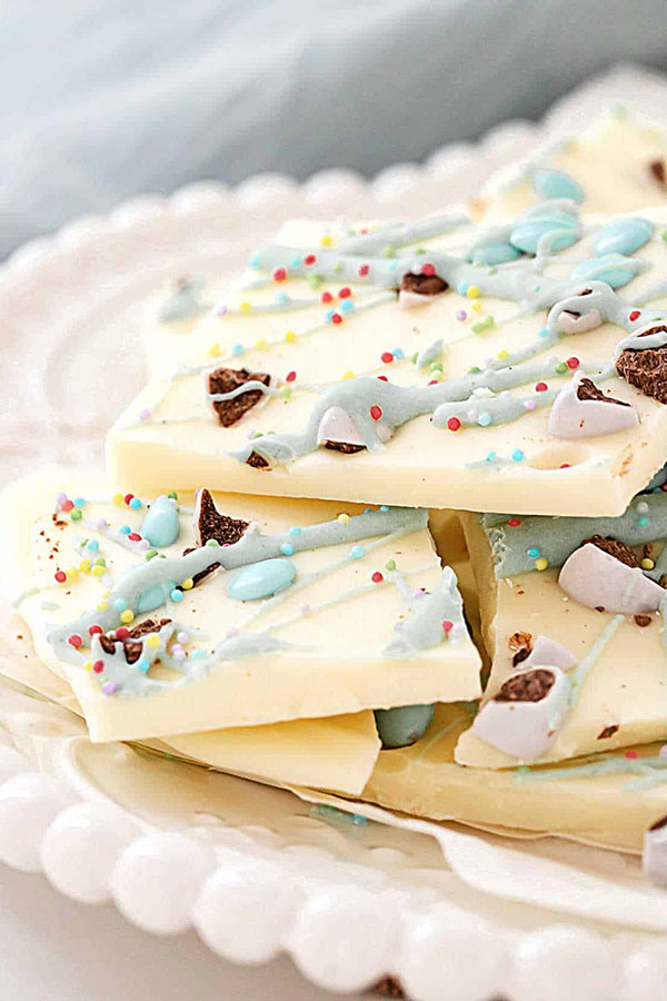 a plate stacked with white chocolate bark made with Easter candies