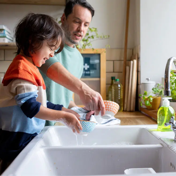 a father and son washing dishes together