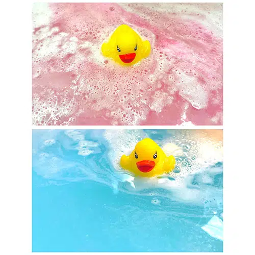 a rubber ducky with a bath bomb attached creates pink or blue water