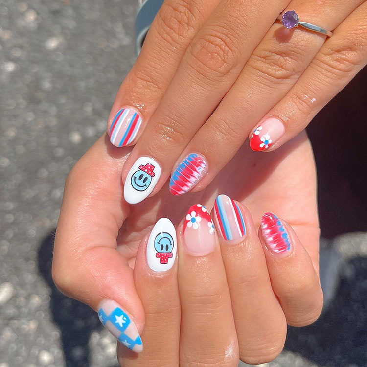 nails featuring various designs including a smiley face wearing a hat, stripes, and stars on blue checks