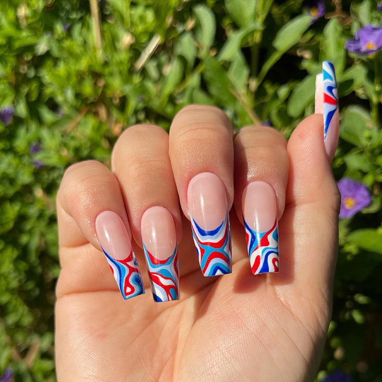 coffin-shaped French tips featuring red, white, and blue swirly line designs