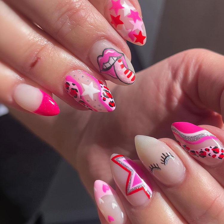 Patriotic-themed pink nail designs on almond-shaped nails, including the Rolling Stones mouth, eyelashes, and stars