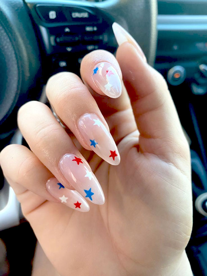 almond acrylic nails featuring red, white, and blue nail stickers