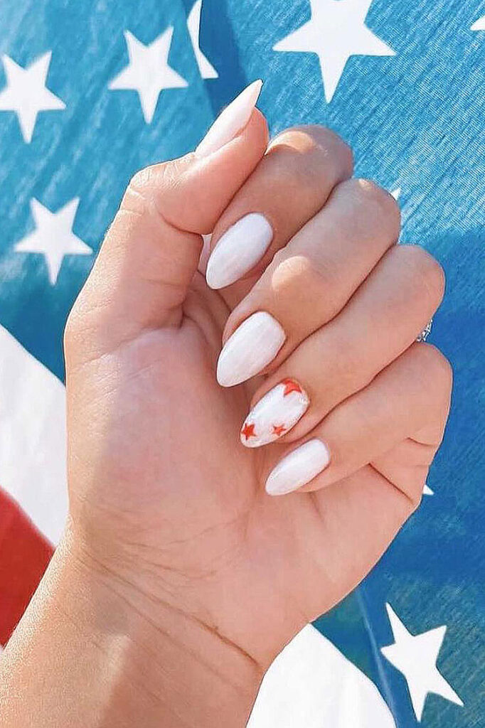 white almond-shaped nails with one accent nail featuring red stars