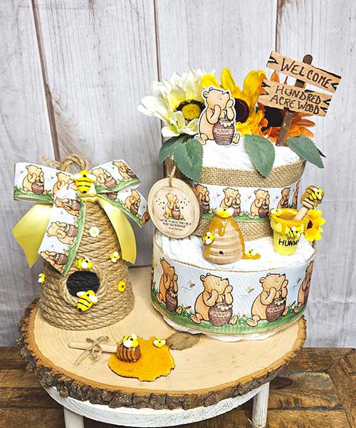 a classic Pooh-themed centerpiece and diaper cake set on top of a wood slice