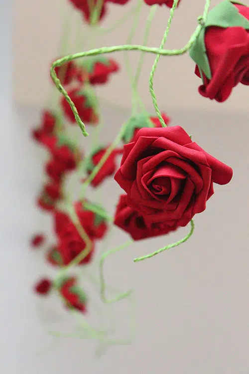 a garland of fake roses on paper rope vines hanging from the ceiling