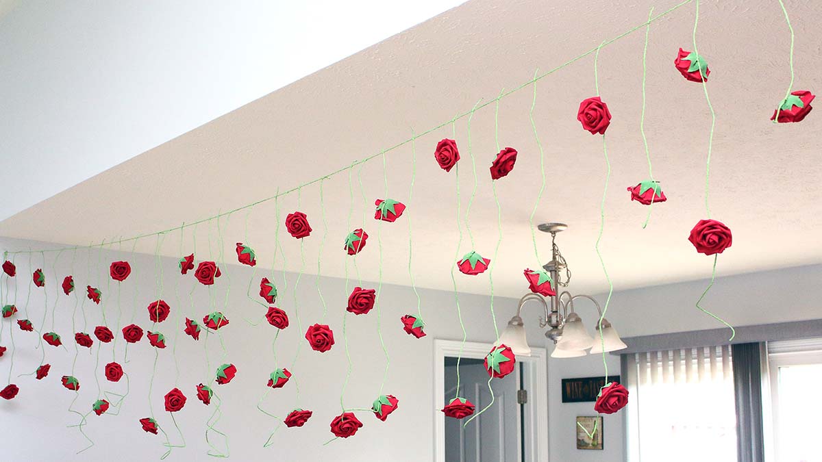 a wide view of a long homemade rose garland hanging between two rooms