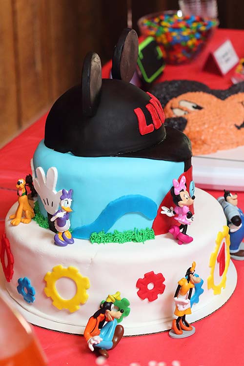 a side view of a three-tier fondant Mickey Mouse Clubhouse cake