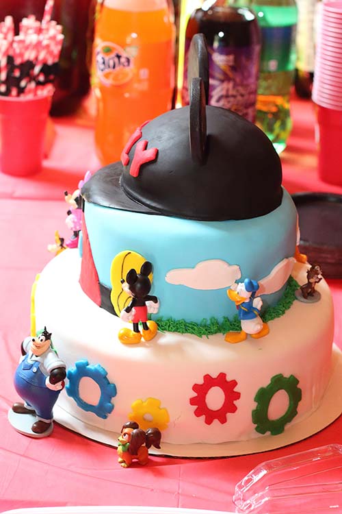 a side view of a three-tier fondant Mickey Mouse Clubhouse cake