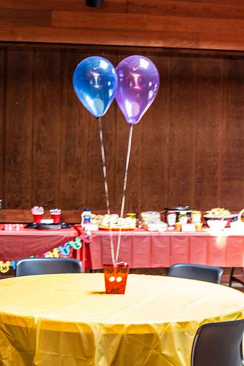 a simple Mickey Mouse table centerpiece with a bucket resembling Mickey's pants and balloons hovering above