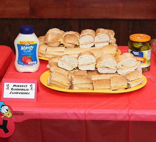 two platters of club sandwiches with a card that says "Mickey's Clubhouse Sandwiches"