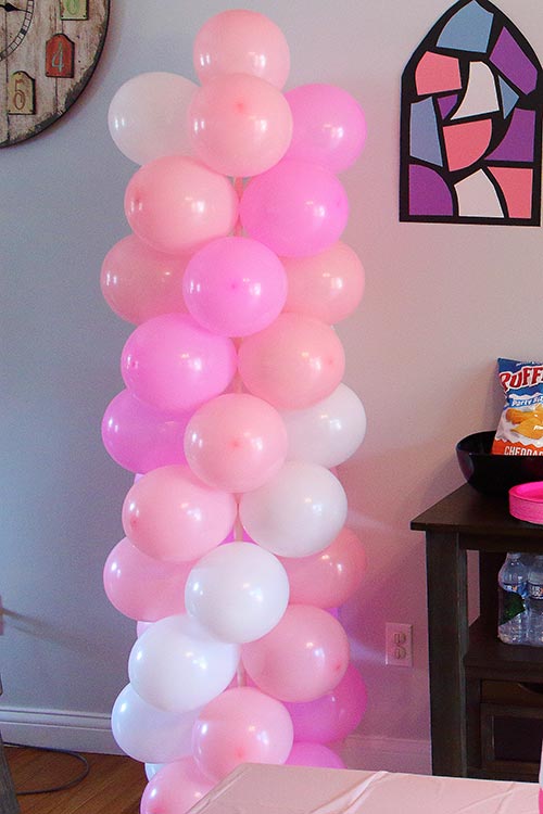 a balloon column featuring pink, light pink, and white balloons