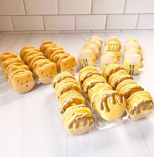 yellow macarons decorated to look like Pooh's face, a honey bee, and a honey pot