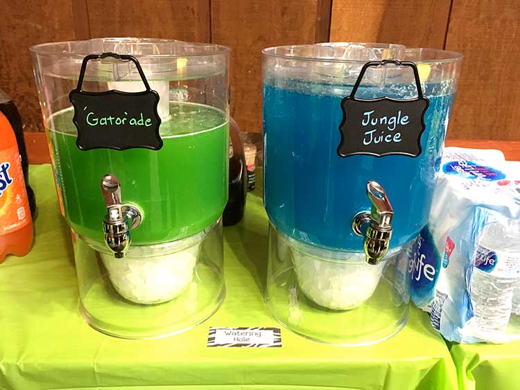 two drink dispensers, one with a green drink labeled "'Gator'ade" and the other blue labeled "Jungle Juice"; a food card is between them labeled "Watering Hole"