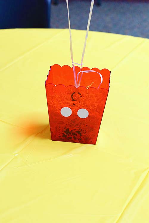 a red plastic bucket centerpiece with two white circles attached so that it resembles Mickey Mouse's pants