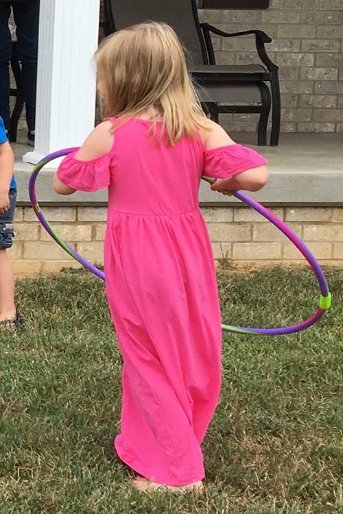 a little girl wearing a hot pink cold shoulder maxi dress