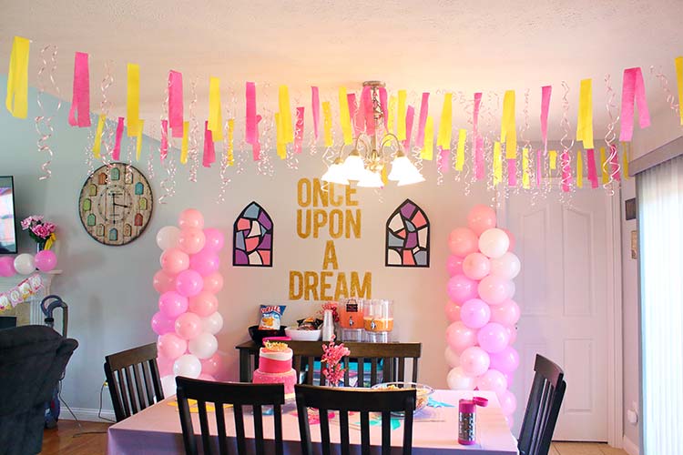 a kitchen area fully decorated in pink, yellow, and white decor for a Sleeping Beauty birthday party