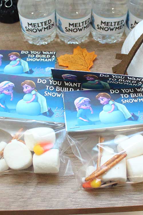 bags of edible snowman-building kits with tags featuring young Elsa and Anna that say "Do you wanna build a snowman?"