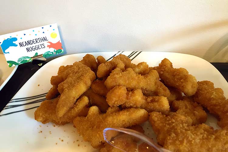a plate of dinosaur-shaped chicken nuggets labeled "Neanderthal Nuggets"