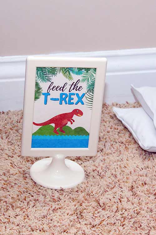 a framed sign that says "feed the T-rex" with an illustrated T-rex