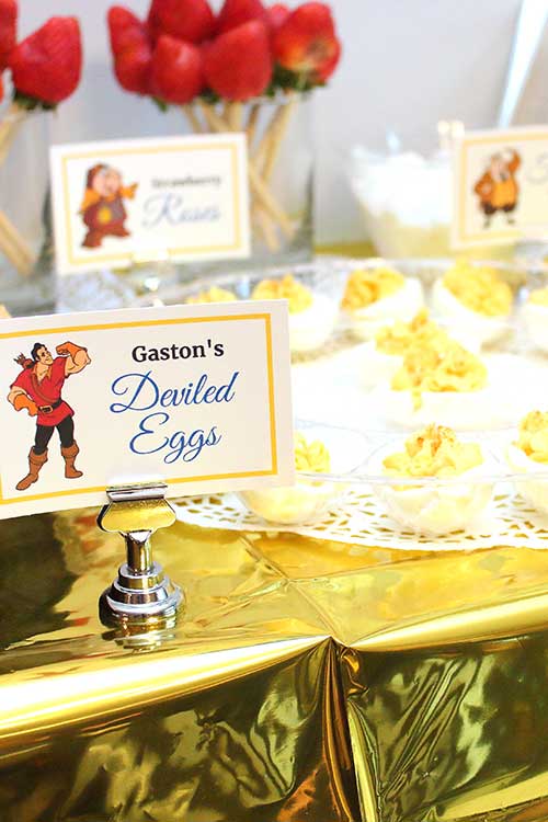a platter of deviled eggs with a food card labeled "Gaston's Deviled Eggs" featuring the named character