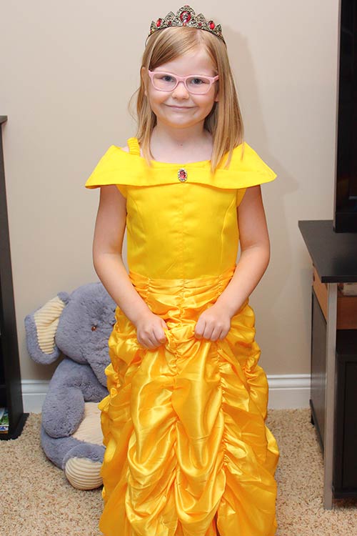 a young girl wearing a golden-yellow ballgown like Belle's from Beauty and the Beast