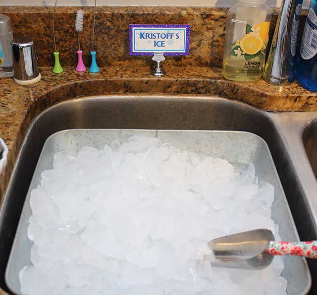 a bucket of ice in a sink labeled "Kristoff's ice"