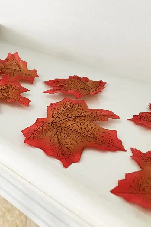 faux red fall leaves on a mantle