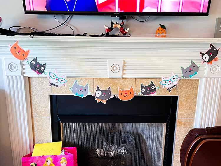 cat garland hanging from a fireplace