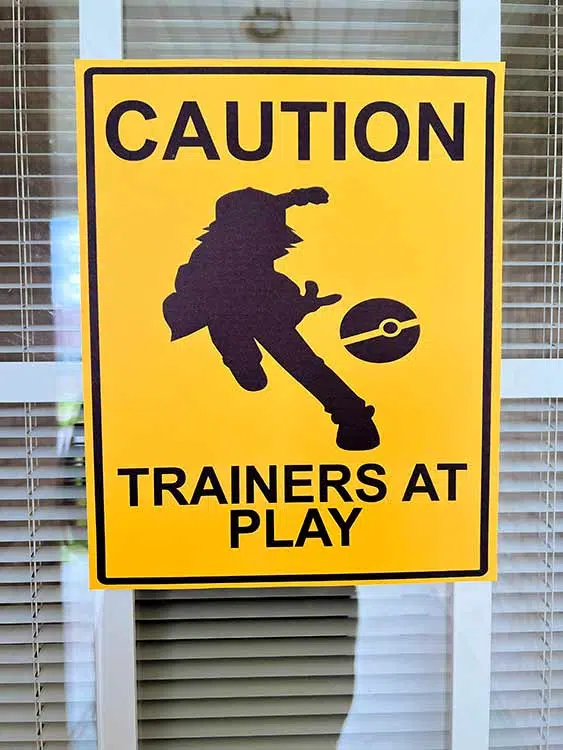 a caution sign that says "Trainers at Play"