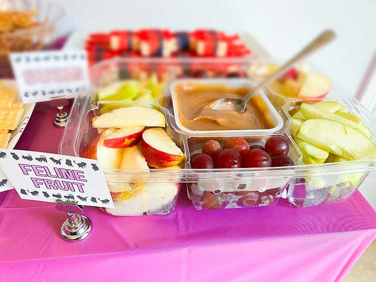 a fruit tray of apples, grapes, and caramel